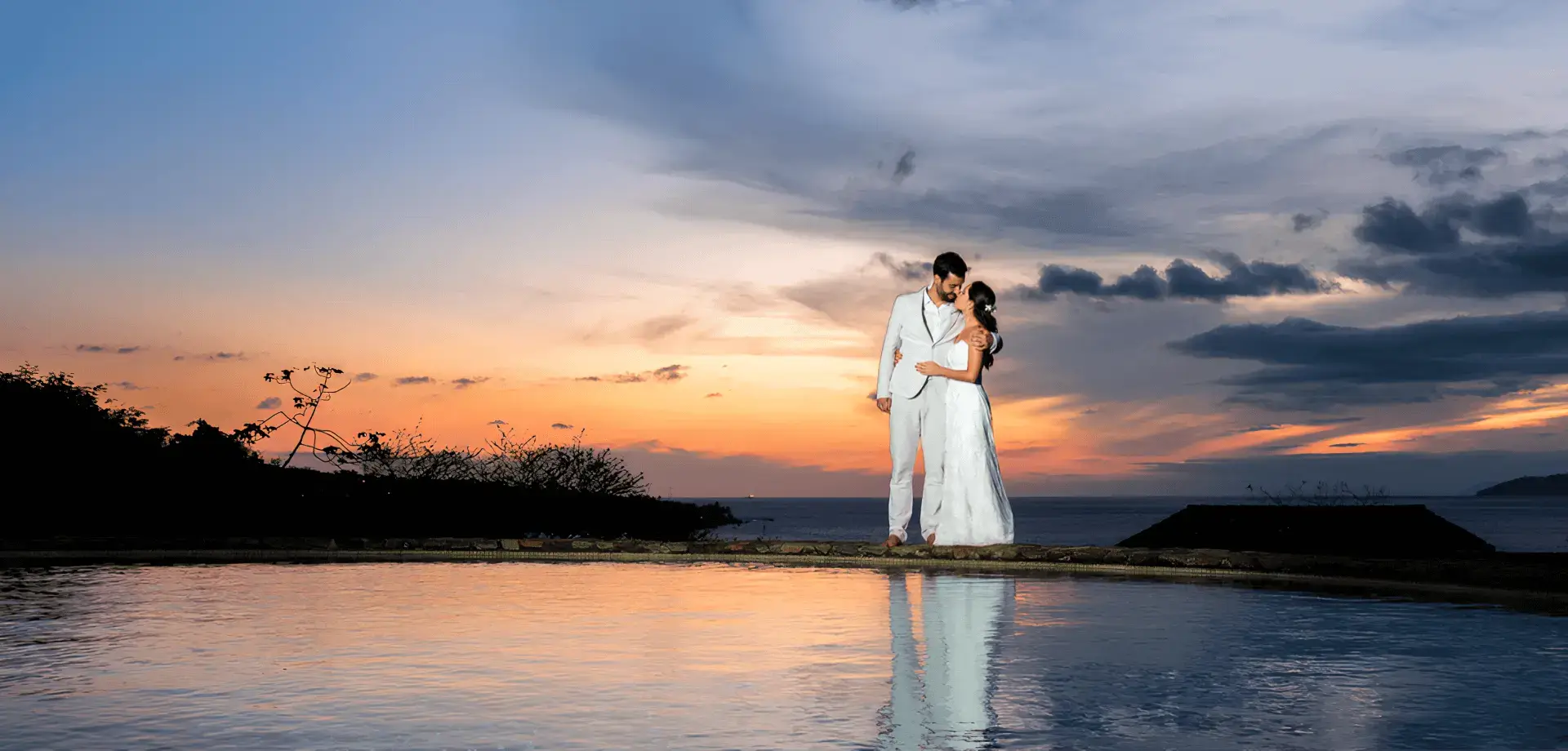 Um casal se beijando em frente a um lago